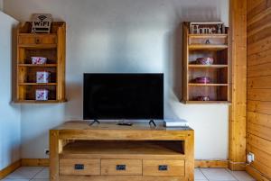 een tv op een houten tafel bij Appartement l'éterlou in Sallanches