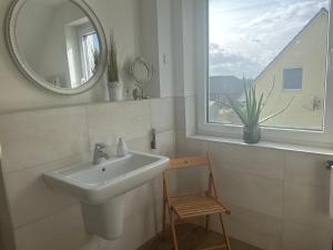 ein Badezimmer mit einem Waschbecken, einem Spiegel und einem Stuhl in der Unterkunft Erholung pur für die ganze Familie in Ribnitz-Damgarten