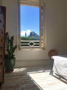 トゥルヴィル・シュル・メールにあるcharmante maison de pêcheurのベッドルーム1室(家の景色を望む窓付)