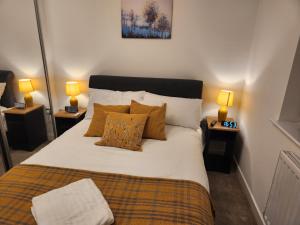Beautifully Fab 3 bedroom 4 beds New home 8 guests Stretford Trafford في مانشستر: غرفة نوم بسرير ومخدات ومصباحين
