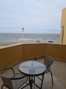 einen Tisch und zwei Stühle auf einem Balkon mit Meerblick in der Unterkunft Pastello guest house in Maputo