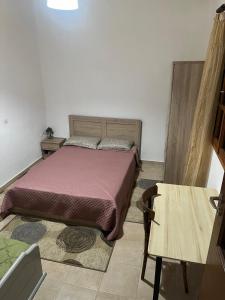 sypialnia z łóżkiem i drewnianym stołem w obiekcie Antoneiko house 