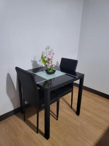 a black table with a black chair and a bowl of flowers at Kate Building in Imus