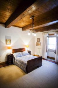 een slaapkamer met een groot bed en een houten plafond bij Casa do Cimo da Vila in Mondim da Beira