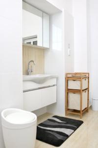 ein Badezimmer mit einem weißen WC und einem Waschbecken in der Unterkunft Herman Apartment Cisnadie in Cisnădie