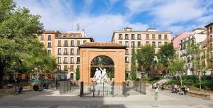 una estatua de un caballo en un arco en una ciudad en Apartamentos Malasaña, en Madrid