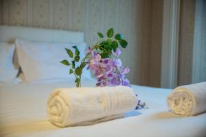 two towels on a bed with a vase of flowers at ShortMi Montello in Milan