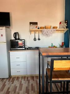 Las Heras的住宿－Monoambiente lo de Carola Mendoza，厨房配有桌子、微波炉和冰箱。