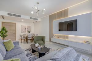 sala de estar con sofá azul y mesa en #54 High End 2BR in Mirdif hills en Dubái