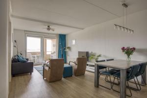 een eetkamer en een woonkamer met een tafel en stoelen bij Appartement Strand Makkum in Makkum
