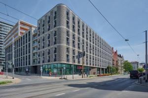 a large building on a city street with a street at Cosy Studio with access to Gym and Spa Area by Renters in Wrocław