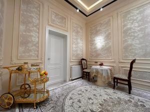 una habitación con mesa y sillas y una habitación con pared en Guest house Comfort, en Samarkand