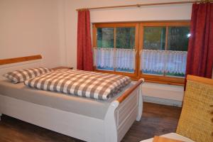 a bedroom with a bed and a window at Holzhammer Hof in Bayerbach