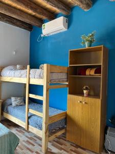 a bedroom with bunk beds and a blue wall at Monoambiente lo de Carola Mendoza in Las Heras