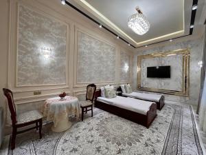 1 dormitorio con cama, mesa y TV en Guest house Comfort, en Samarkand
