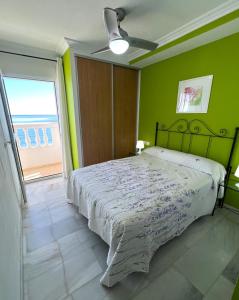 Schlafzimmer mit einem Bett mit grünen Wänden und einem Fenster in der Unterkunft Manilva Sabinillas Sea Views by Homing in Manilva