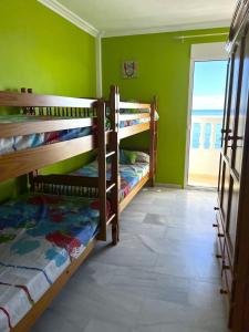 Zimmer mit 2 Etagenbetten in einem Zimmer mit Fenster in der Unterkunft Manilva Sabinillas Sea Views by Homing in Manilva