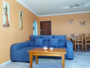 ein blaues Sofa im Wohnzimmer mit einem Tisch in der Unterkunft Manilva Sabinillas Sea Views by Homing in Manilva
