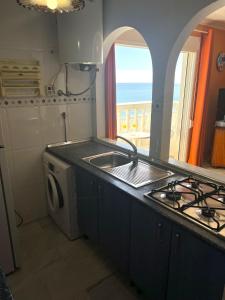 eine Küche mit einer Spüle und einer Waschmaschine in der Unterkunft Manilva Sabinillas Sea Views by Homing in Manilva