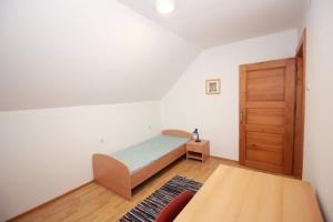 a bedroom with a bed and a wooden door at Green Oasis in Mozirje