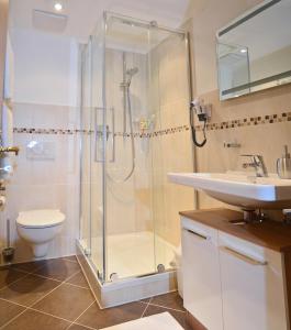 a bathroom with a shower and a toilet and a sink at Ferienwohnungen Woferllehen in Berchtesgaden +14 photos