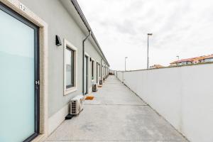 an empty hallway of a white building with a window at Pestana Cozy House in Porto