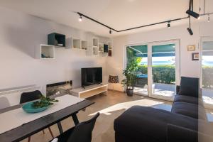 a living room with a couch and a tv at Apartment Lovro in Punat