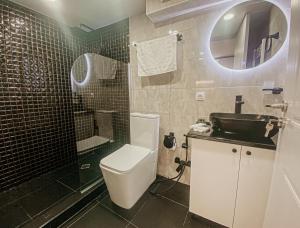 y baño con aseo, lavabo y espejo. en Luxury Duplex Studios - City Center en Tiflis