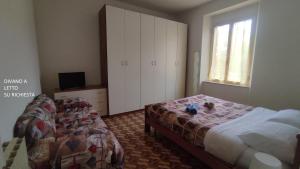 1 dormitorio con 2 camas, TV y ventana en Appartamento Via Ponchielli, en Perugia