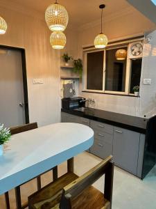 a kitchen with a table and chairs and chandeliers at The Good Vibes Studio : AC, WiFi, Smart Tv in Pune