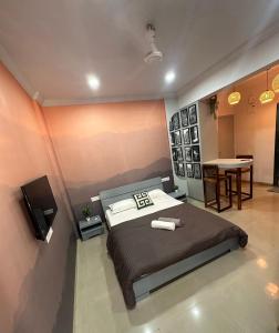 a bedroom with a bed and a tv and a table at The Good Vibes Studio : AC, WiFi, Smart Tv in Pune
