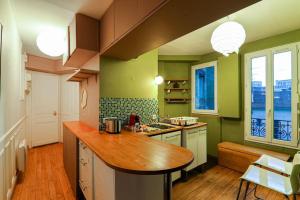 eine Küche mit grünen Wänden und einer hölzernen Arbeitsplatte in der Unterkunft Studio Tour Eiffel Garibaldi in Paris