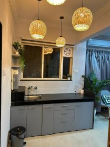 a kitchen with a sink and two chandeliers at The Good Vibes Studio : AC, WiFi, Smart Tv in Pune