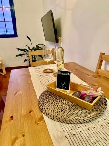 una mesa de madera con una botella de vino y copas en Casa Calandrilla, en Caleta de Caballo