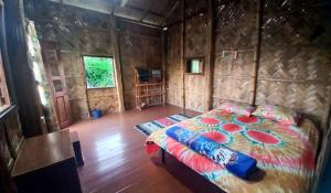 sypialnia z łóżkiem w drewnianym pokoju w obiekcie Oronner Din Ratri w mieście Sreemangal