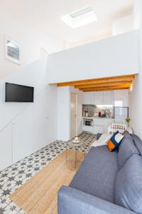 sala de estar con sofá azul y cocina en Pestana Cozy House, en Oporto