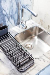 a metal drying rack next to a sink at Pestana Cozy House in Porto
