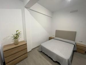 a small bedroom with a bed and a vase of flowers at Casa Vera in San Sebastián de la Gomera