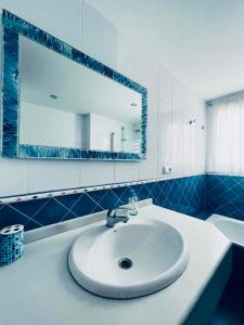 Un baño con un lavabo blanco y un espejo. en OTONELL CENTRO, en Málaga