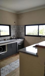 a kitchen with two windows and a counter top at Guidai Alojamiento in Tacuarembó