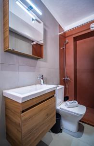 a bathroom with a white sink and a toilet at Nestia urban apartments in Volos