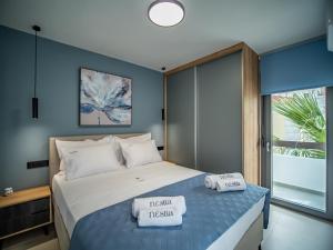 1 dormitorio con 1 cama con 2 toallas en Nestia urban apartments, en Volos