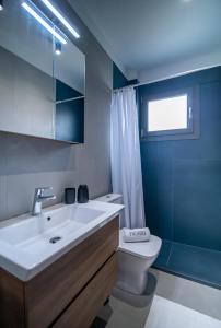 a bathroom with a white sink and a toilet at Nestia urban apartments in Volos