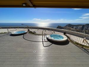 two hot tubs sitting on a balcony overlooking the ocean at Intempo Residence in Benidorm