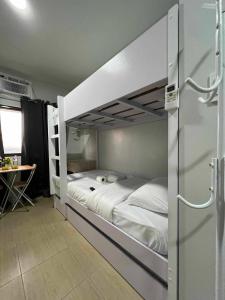 馬尼拉的住宿－Iza's Alabang Studio Apartment，一间卧室设有两张双层床和一张桌子