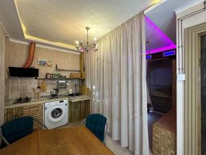 a kitchen with a table and a kitchen with a washing machine at City Center Beach side Hut in Tbilisi City +9 photos