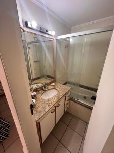 a bathroom with a sink and a shower at Flat Capitania Varam Ap 3053 in Guarujá