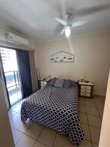 a bedroom with a bed and a ceiling fan at Flat Capitania Varam Ap 3053 in Guarujá