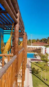 une clôture en bois avec un hamac à côté d'une piscine dans l'établissement BRISAS DE FORTIM VILLAGE, à Fortim