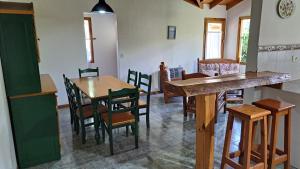 una cucina e una sala da pranzo con tavolo e sedie di La Colella a San Martín de los Andes